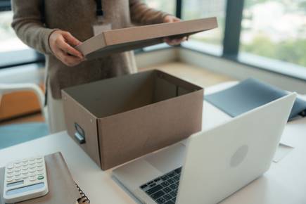Woman opening box to pack - Wrongful Termination